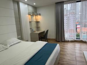 a bedroom with a bed and a desk and a window at Skyline hotel in Phnom Penh