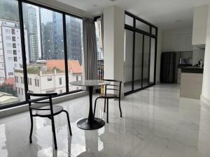 a table and chairs in a room with large windows at Skyline hotel in Phnom Penh