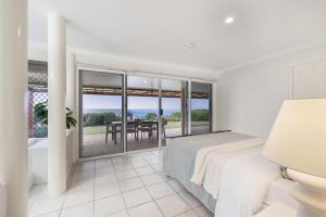 a bedroom with a bed and a view of a table at Whale Song House in Bargara