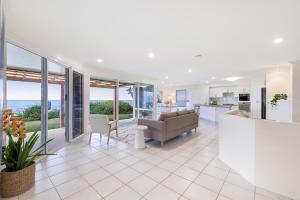 a kitchen and living room with a view of the ocean at Whale Song House in Bargara