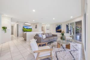 a living room with a couch and a table at Whale Song House in Bargara