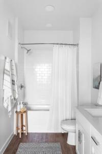 a white bathroom with a toilet and a sink at Luxury 1bedroom 1bath Tech Hub in Austin +13 photos