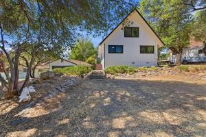 a white house with a tree and a driveway at Remodeled Yosemite Cabin Sleeps 12 in Groveland