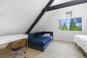 a bedroom with a blue couch and a bed and a window at Remodeled Yosemite Cabin Sleeps 12 in Groveland
