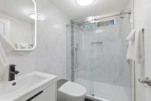 a white bathroom with a shower and a sink at Remodeled Yosemite Cabin Sleeps 12 in Groveland +26 photos