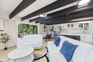 a living room with white furniture and a kitchen at Remodeled Yosemite Cabin Sleeps 12 in Groveland