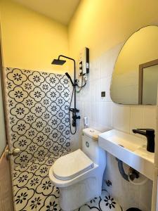 a bathroom with a white toilet and a sink at Dune House Phan Thiết in Ấp Bình Hưng