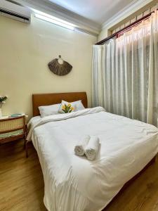 a bedroom with a white bed with towels on it at Dune House Phan Thiết in Ấp Bình Hưng