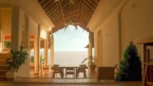 a dining room with a table and a view of the ocean at Aguamiel Manzanillo in Puerto Escondido