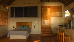 a bedroom with a bed with green pillows at Aguamiel Manzanillo in Puerto Escondido