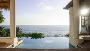 a view of the ocean from a house with a swimming pool at Aguamiel Manzanillo in Puerto Escondido