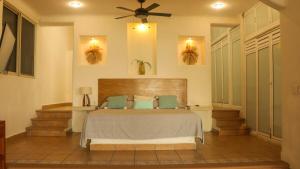 a bedroom with a bed and a ceiling fan at Aguamiel Manzanillo in Puerto Escondido +3 photos