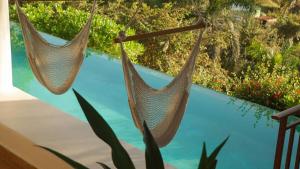 two hammocks hanging next to a swimming pool at Aguamiel Manzanillo in Puerto Escondido