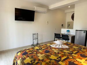 a bedroom with a bed with a colorful quilt at Bungalows Omar Deluxe in Rincon de Guayabitos