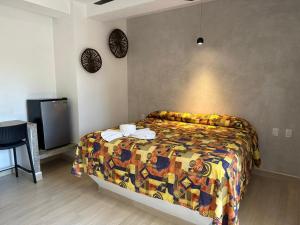 a bedroom with a bed with a colorful blanket at Bungalows Omar Deluxe in Rincon de Guayabitos +44 photos