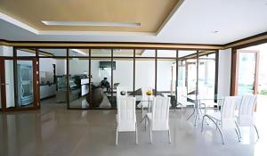 a dining room with white chairs and a table at The Capital Hotel in Roi Et