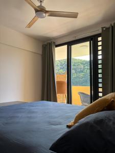 a bedroom with a bed and a ceiling fan at Zen escape-ocean view Papeete in Papeete +18 photos