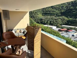a room with a balcony with a couch and a table at Zen escape-ocean view Papeete in Papeete
