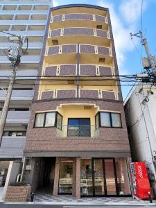 a tall apartment building with a window at West Press Sasebo in Sasebo
