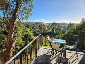 a balcony with a table and chairs and a tree at Tamar Ridge Winery Apartments in Grindelwald