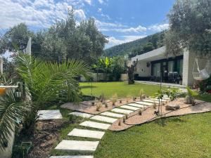 a garden with a stone path in front of a house at Krum's Little Secret Villa in Vourvourou