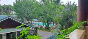 a balcony view of a resort with a pool and trees at DJ Paradise Hotel in Tikay