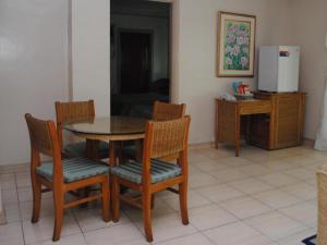 a dining room with a table and chairs and a refrigerator at DJ Paradise Hotel in Tikay