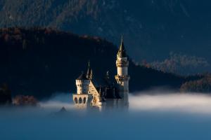 ein Schloss im Nebel vor einem Berg in der Unterkunft Hotel Christine in Eisenberg