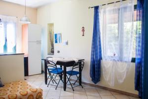 una stanza con un tavolo e due sedie e una finestra di Appartamento Di Basilia a Bari Sardo