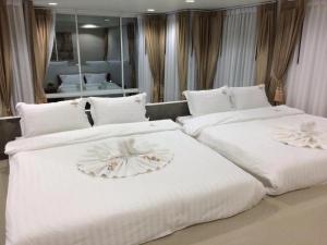 two beds in a hotel room with white sheets at The Key Hotel in Ko Lipe