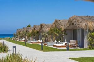a resort with a thatch roof on a beach at LYV Boutique Cabana in Marsa Matruh