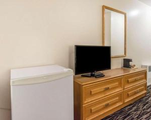 a room with a refrigerator and a television on a dresser at Econo Lodge in Temiskaming Shores +28 photos