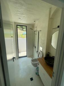 a bathroom with a toilet and a sink and a window at Krum's Little Secret Villa in Vourvourou +25 photos