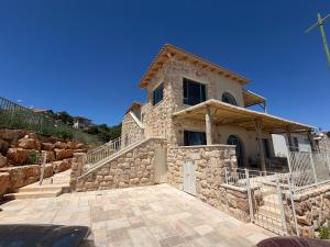 a stone house with a staircase leading up to it at מול האופק horizonview in Kammon