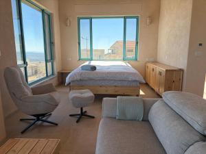 a living room with a bed and a couch and a window at מול האופק horizonview in Kammon