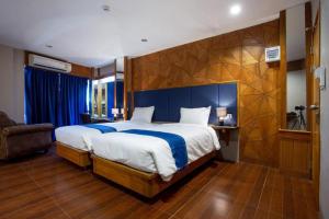 a bedroom with a large bed with a blue headboard at Vince Sakon in Sakon Nakhon