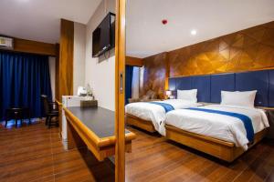 a hotel room with two beds and a desk at Vince Sakon in Sakon Nakhon +25 photos