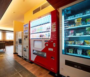 a red vending machine in a room with food at Hotel B4T Kakunodate in Senboku