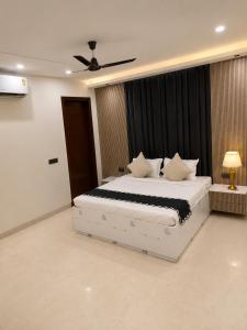 a bedroom with a white bed with a ceiling fan at Bell Rooms Hotel in Noida