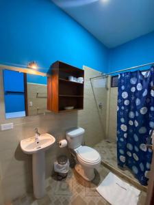 a bathroom with a white toilet and a sink at Hotel del Sur in San Juan del Sur
