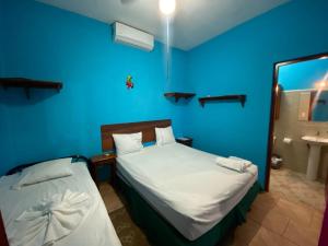a blue room with a bed and a sink at Hotel del Sur in San Juan del Sur
