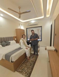 two people standing in a bedroom with a bed at Hotel Brijraj Dham in Govardhan +4 photos