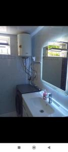 a small bathroom with a sink and a window at Modern Homestay in Arslanbob
