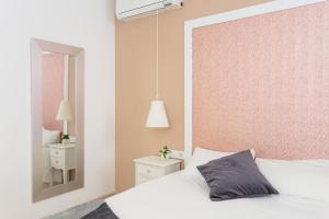 a bedroom with a white bed and a mirror at Casa Cosi Letamendi in Barcelona