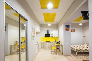 a kitchen and dining room with a yellow ceiling at Apartment on Pekarska street зі світлом! in Lviv