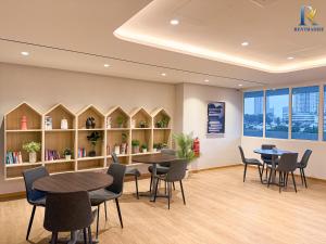 a waiting room with tables and chairs and bookshelves at Trellis Residence by RR JBcity in Johor Bahru