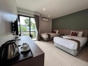a hotel room with two beds and a television at Baan Nan B&B Hotel in Nan