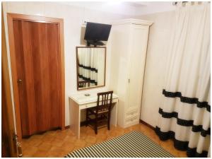 a room with a desk and a mirror and a chair at Hotel Pisani in Taranto