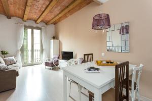 een keuken en een woonkamer met een witte tafel en stoelen bij Casa Cosi Letamendi in Barcelona
