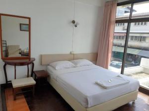 a bedroom with a white bed and a window at SA hotel in Trat